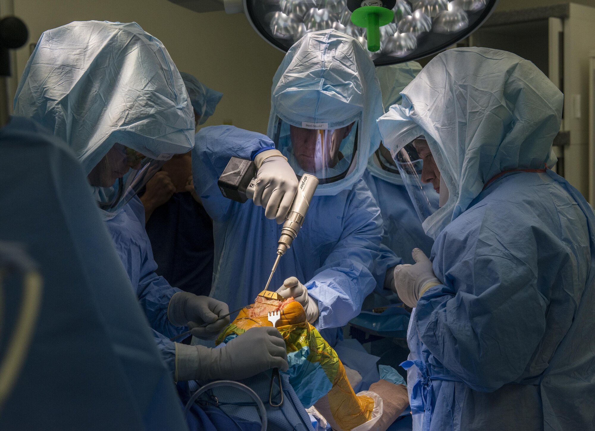 Airman First Class Athena Lagman, a surgical technician, 60th Surgical Operations Squadron here at Travis AFB, California had the opportunity to spend the day with Col. Joel Jackson, 60th Air Mobility Wing commander, Jan 15, 2016.  Lagman assisted the surgical team during a knee replacement operation. The Works With Airman Program allows Col. Jackson to accompany a junior Airman as he or she accomplishes their daily duties and Airmen to have the opportunity to gain a strategic-level perspective of the mission. Doctors fit an artificial knee component into the leg of the patient. (U.S. Air Force Photo by Heide Couch/Released)