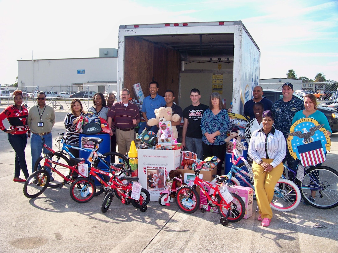 Employees from Defense Logistics Agency Aviation at Jacksonville, Florida pose with the toys they and Navy employees from Fleet Readiness Center Southeast’s Avionics Shop collected for the annual Toys for Tots Program, December 12, 2016.  