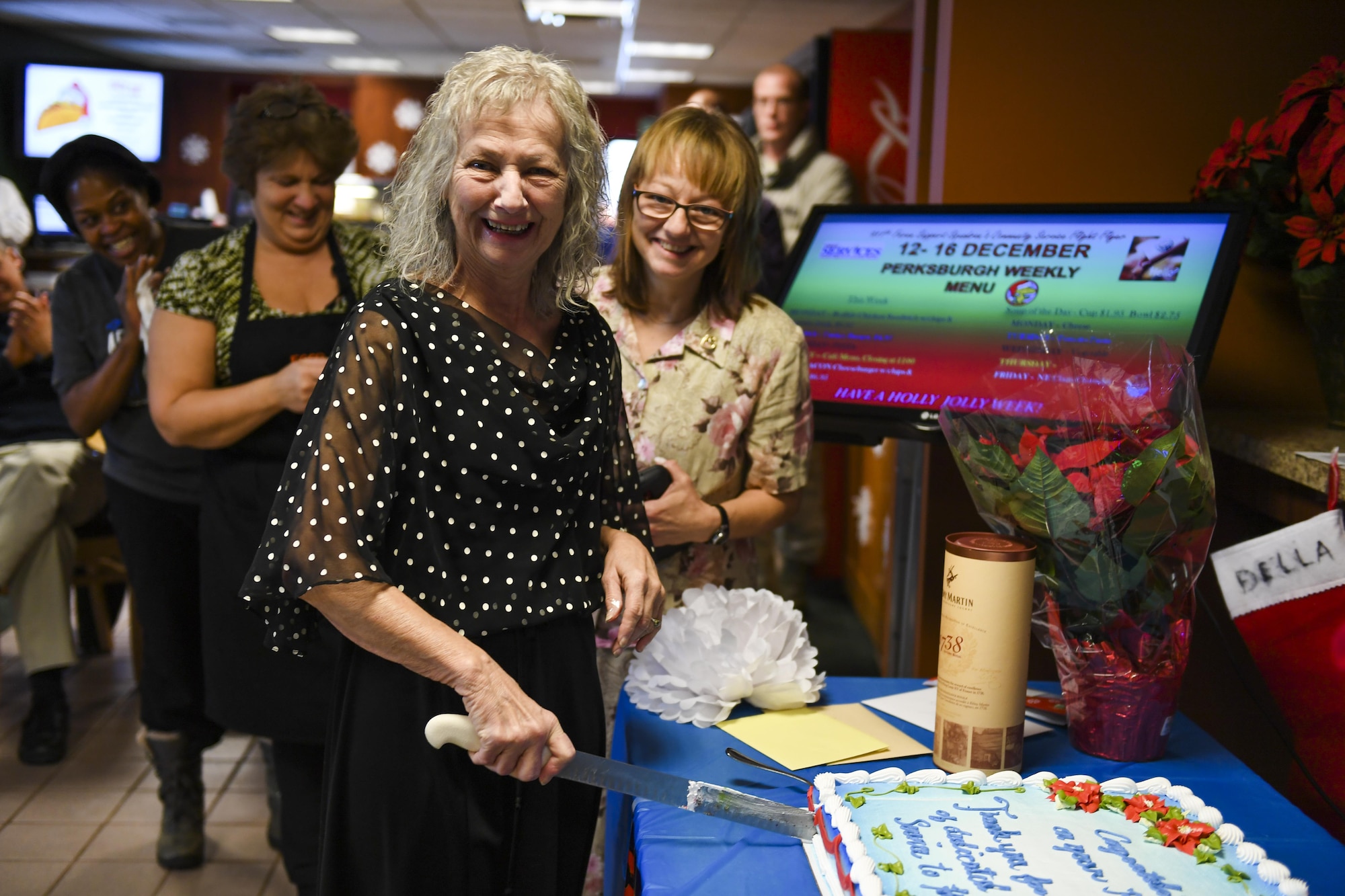 Joyce Miller, server with the 911th Airlift Wing Services Personnel, cuts a congratulatory cake at her retirement party December 14, 2016, at the Pittsburgh International Airport Air Reserves Station, Pa. Miller’s retirement comes after 45 years of dedicated service on base. (U.S. Air Force photo by Senior Airman Beth Kobily)