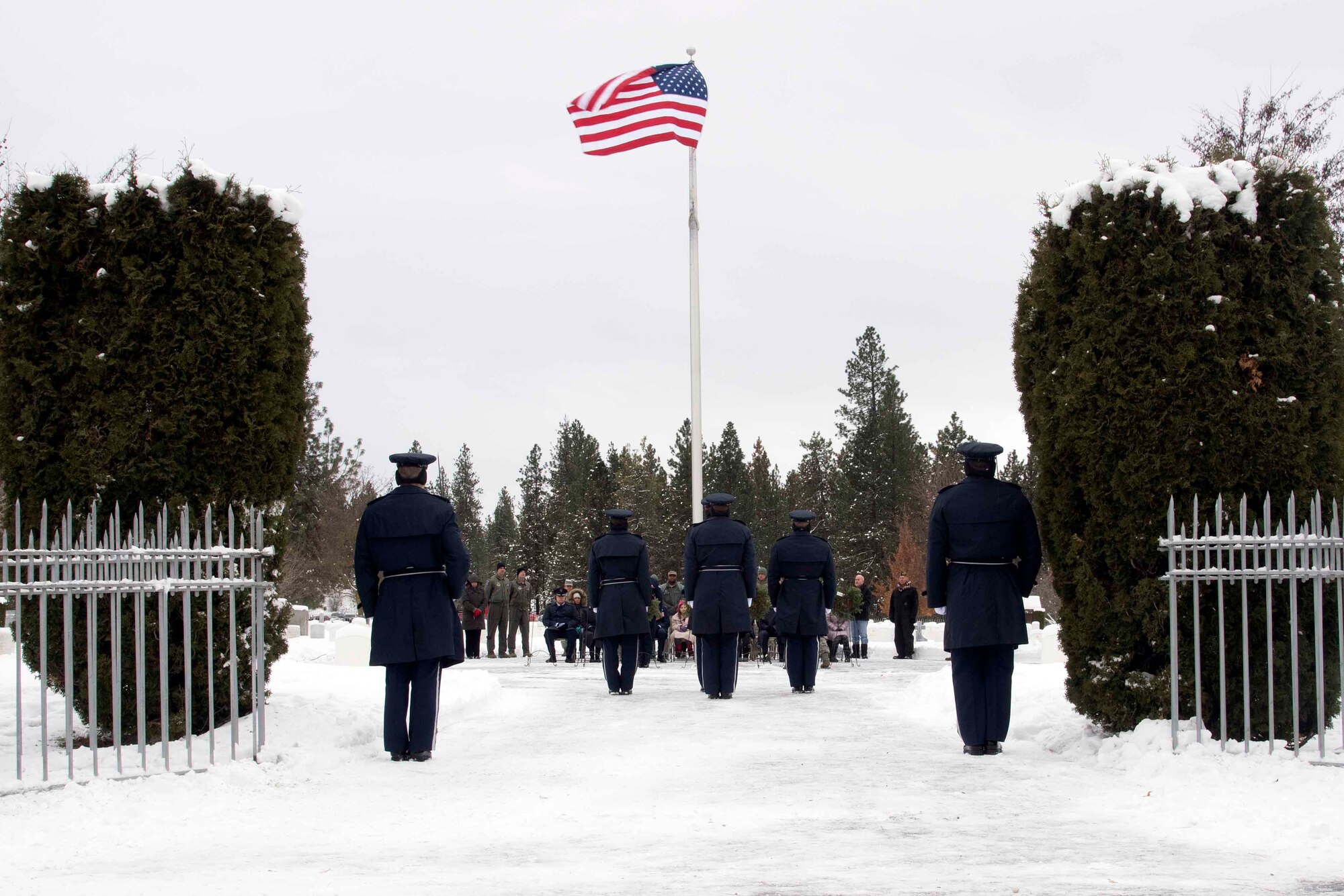 Fairchild Honor Guard Airmen stand at attention Dec. 19, 2016, during a Wreaths Across America ceremony at Fort George Wright Cemetery, Spokane, Washington. The ceremonial guardsmen supported the ceremony by presenting of colors, playing of taps, and a three-volley rifle salute. (U.S. Air Force photo/Senior Airman Nick J. Daniello)