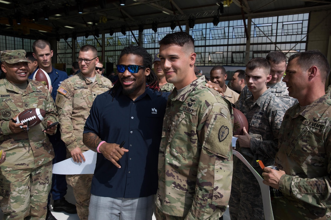 Army Pfc. Scott Wilder takes a photo with NFL running back DeAngelo Williams at the 2016 Pro Bowl Draft show on Wheeler Army Airfield, Hawaii, Jan. 27, 2016. Wilder is an attack helicopter repairer assigned to the 2-6 Cavalry Regiment. U.S. Army photo by Sgt. Daniel K. Johnson