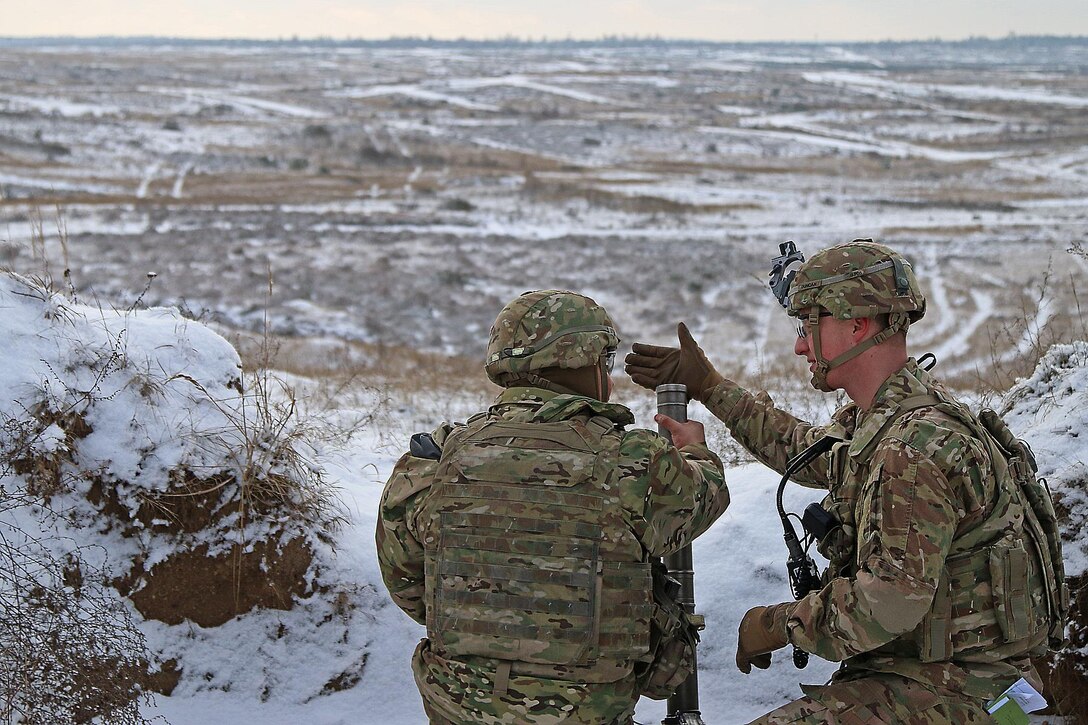 Army Capt. Thomas Duncan, right, instructs Army Sgt. Francisco Martinez on mortar firing procedures during a live-fire exercise in Konotop, Poland, Jan. 18, 2016. Duncan is the commander of the 3rd Squadron, 2nd Cavalry Regiment and Martinez is assigned to the 3rd Squadron, 2nd Cavalry Regiment. Army photo by Sgt. Paige Behringer
