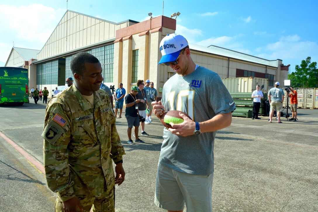 New York Giants quarterback Eli Manning signs an autograph for a member of the 25th Combat Aviation Brigade, 25th Infantry Division, during the 2016 Pro Bowl Draft show on Wheeler Army Airfield, Hawaii, Jan. 27, 2016. U.S. Army photo by Sgt. 1st Class John Brown