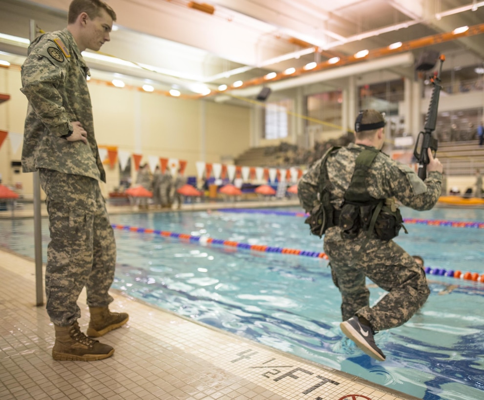 Army ROTC cadet Wesley Pike, left, observes as another cadet jumps into the pool to participate in the 15 meter swim portion of a combat water survival test on Clemson University, S.C., Jan. 28, 2016. Army photo by Staff Sgt. Ken Scar