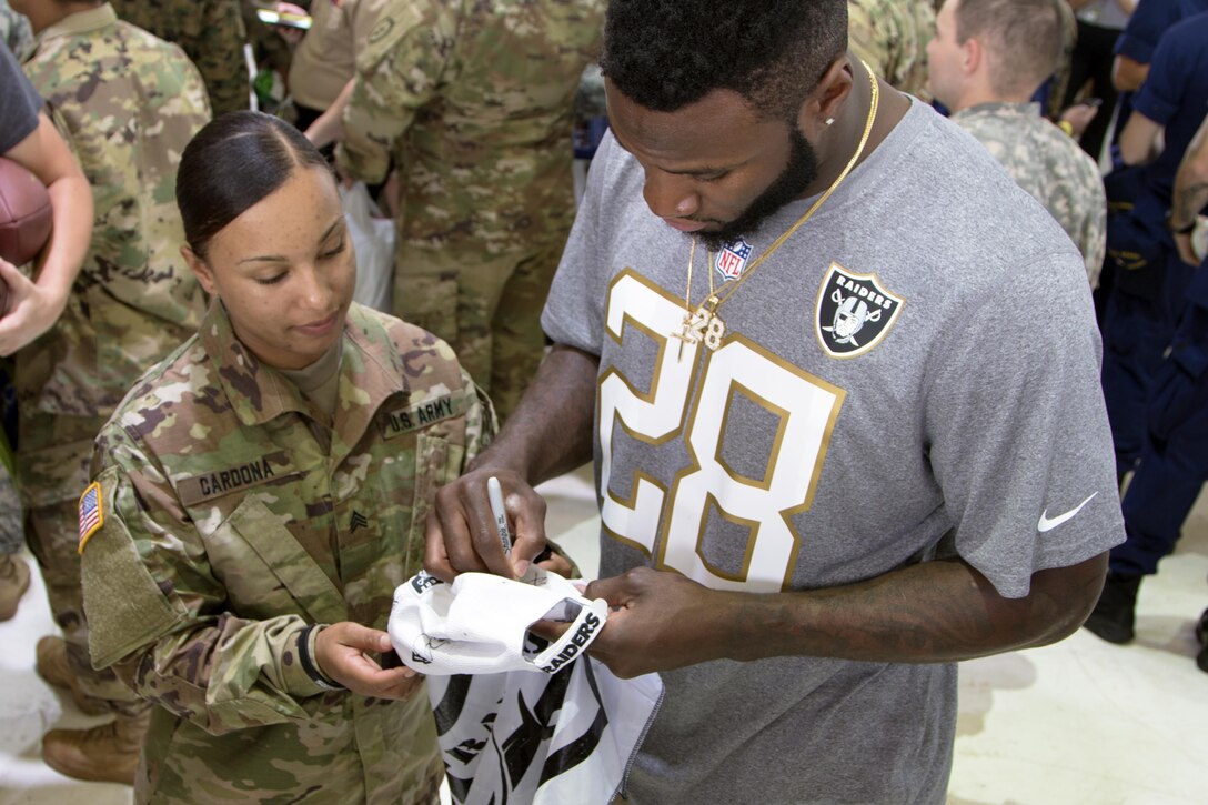 Oakland Raider running back Latavius Murray autographs a hat for a Soldier during the 2016 Pro Bowl Draft show at Wheeler Army Airfield, Hawaii, Jan. 27, 2016. Army photo by Sgt. Kimberly Menzies