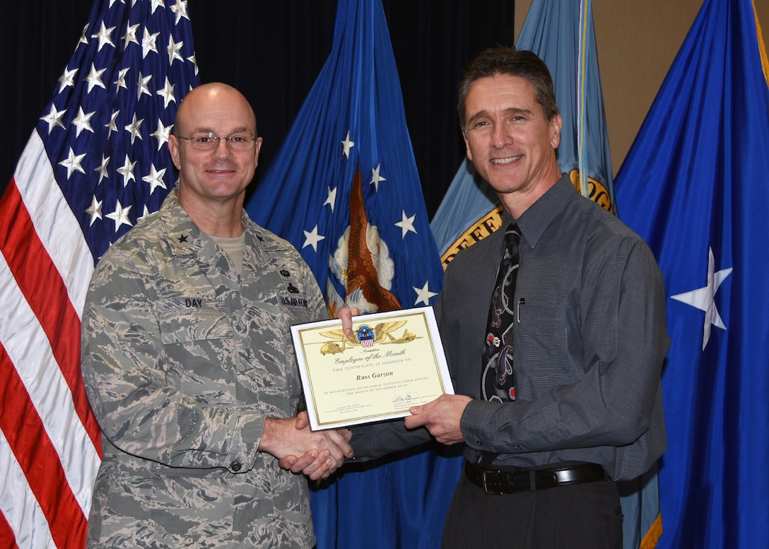 Defense Logistics Agency Aviation Commander Air Force Brig. Gen. Allan Day presents the December Employee of the Month Award to Russ Garzon during a ceremony Jan. 28, 2016, at Defense Supply Center Richmond, Virginia. Garzon is a quality assurance specialist for DLA Aviation Engineering Directorate’s Value Engineering Team. 
