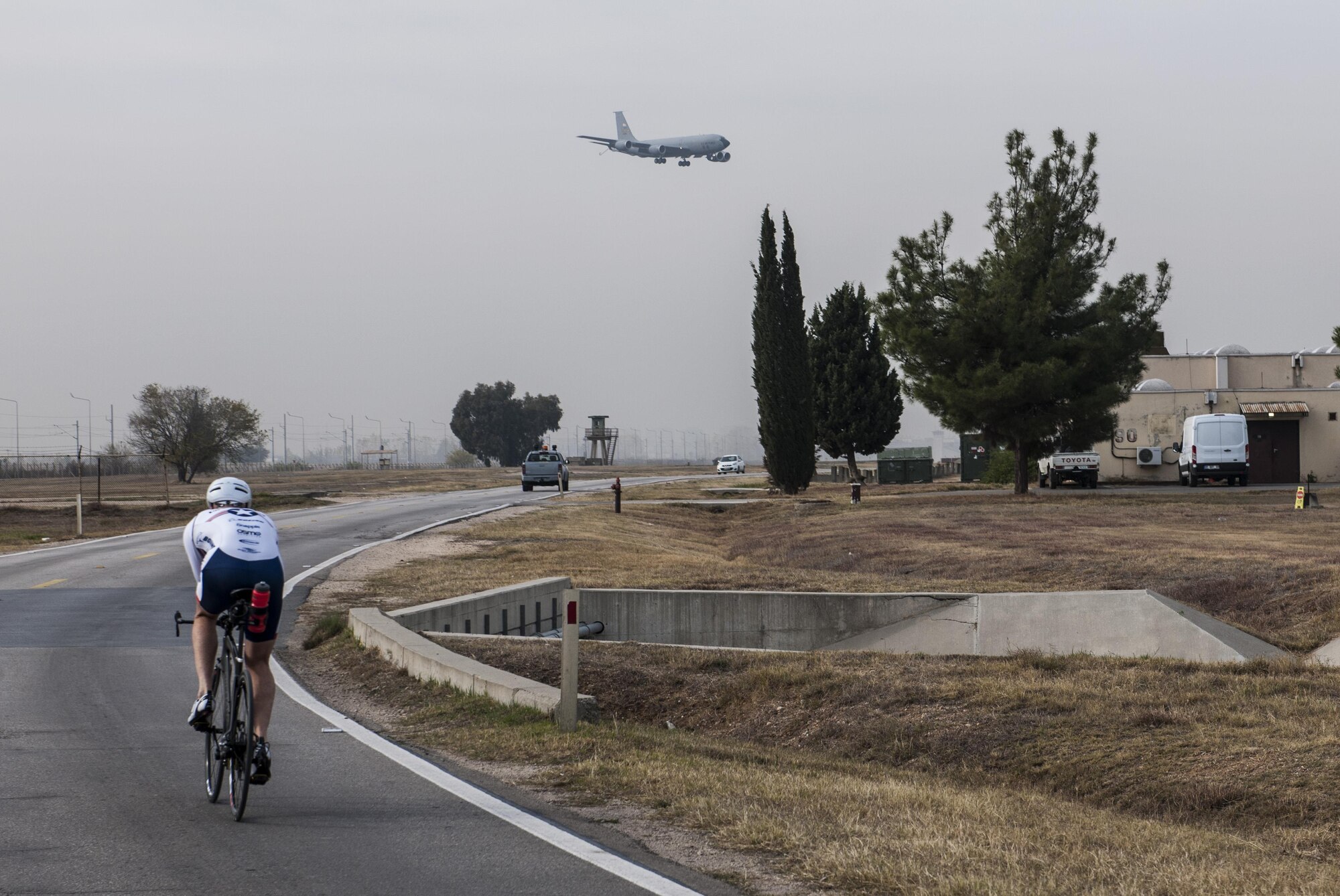 Senior Master Sgt. Jason Chiasson, the 39th Communications Squadron production superintendent, rides past the flightline at Incirlik Air Base, Turkey, Dec. 10, 2015. Chiasson, a member of the Air Force Cycling Team, regularly cycles a variety distances both indoors and outdoors to stay prepared for the races he will participate in as part of the cycling team. (U.S. Air Force photo/Senior Airman Krystal Ardrey)