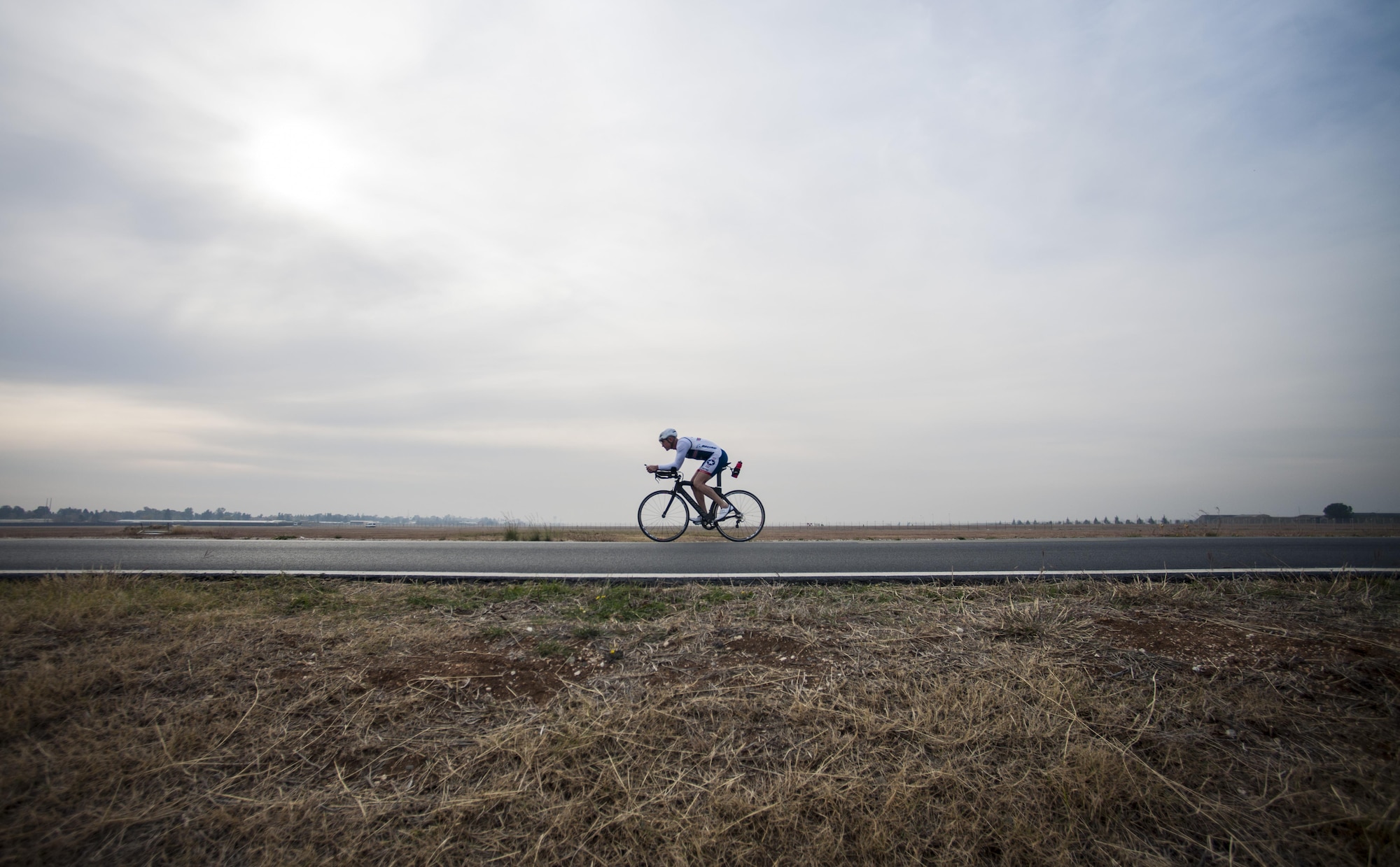 Senior Master Sgt. Jason Chiasson, the 39th Communications Squadron production superintendent, rides around the flightline at Incirlik Air Base, Turkey, Dec. 10, 2015. Chiasson rode 25 miles on his lunch break as part of his training program for the Air Force Cycling Team. (U.S. Air Force photo/Senior Airman Krystal Ardrey)