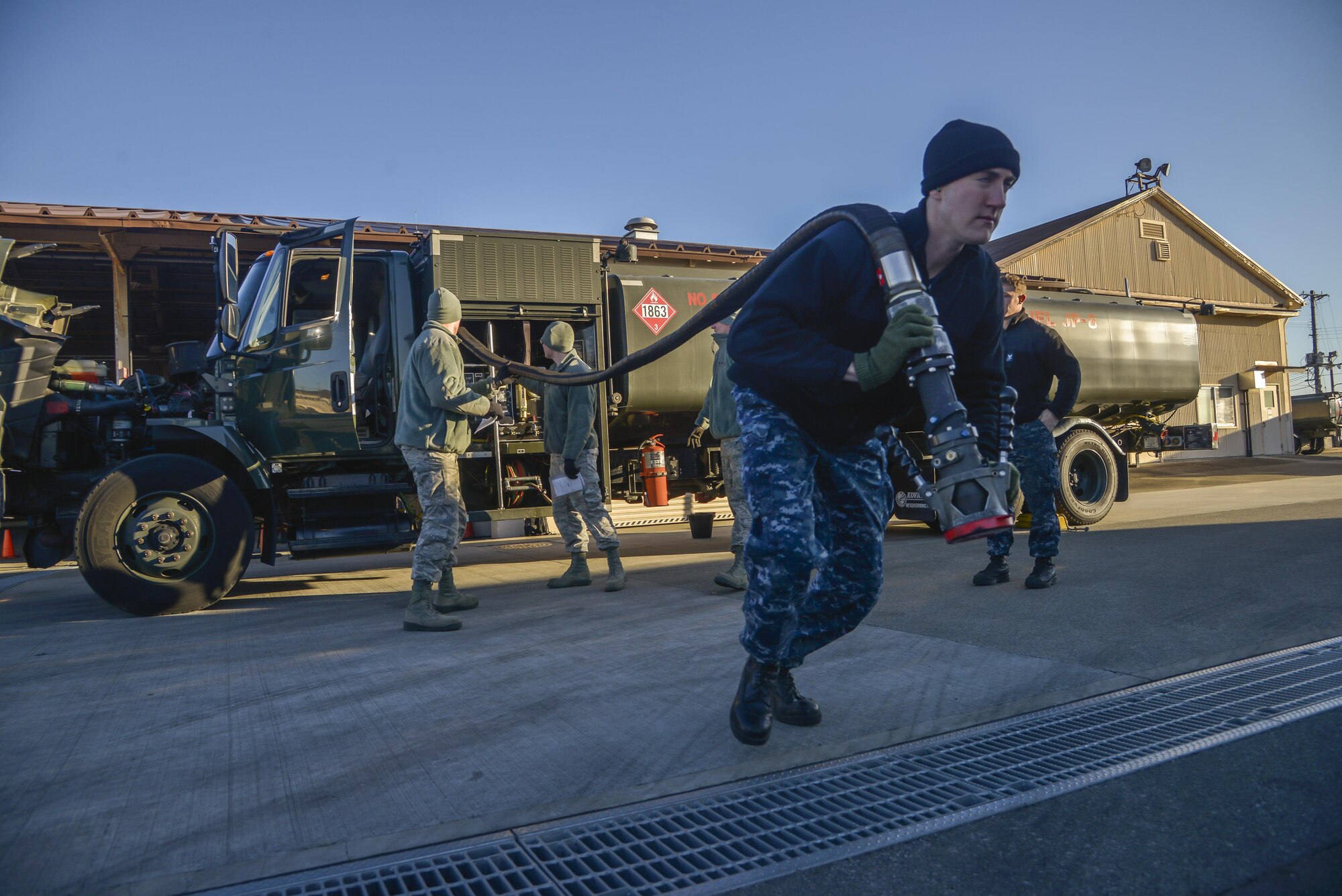 Petty Officer 3rd Class Christian Fakhoury, a Naval Air Field Atsugi Carrier Airborne Early Warning Squadron administrative assistant, pulls a fuel hose for daily inspection at Yokota Air Base, Japan, Jan. 26, 2016. The Navy personnel who received training on the R-11 refueling trucks learned how to drive, service aircraft, perform minor maintenance and how to check fuel samples. (U.S. Air Force photo/Senior Airman David Owsianka)