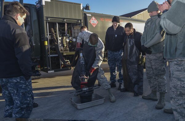 Senior Airman Tyler Sims, a 374th Logistics Readiness Squadron Fuels Management Flight fuels training supervisor, shows Sailors from Naval Air Facility Atsugi how to properly remove a fuel hose nozzle at Yokota Air Base, Japan, Jan. 26, 2016. The training allowed members to be prepared to support U.S. Navy aircraft at Andersen Air Force Base, Guam, during exercise Cope North. (U.S. Air Force photo/Senior Airman David Owsianka)