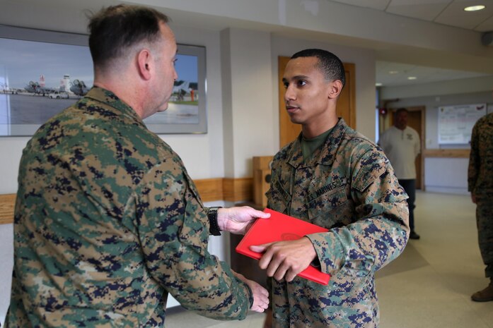 Cpl. Justin McDaniel accepts the Navy and Marine Corps Achievement Medal from Lt. Col. Jeremy Gettings during an award ceremony at Marine Corps Air Station Cherry Point, N.C., Dec. 3, 2015. McDaniel was presented the award for his quick and precise problem solving skills that led to the safe landing of an AV-8B Harrier that had experienced navigational equipment failure. His actions on Dec. 1, 2015, were the product of McDaniel’s extensive training and well-earned confidence in his skills as an air traffic controller. Gettings is the commanding officer of Headquarters and Headquarters Squadron. (U.S. Marine Corps Photo By Cpl. N.W. Huertas/Released) 
