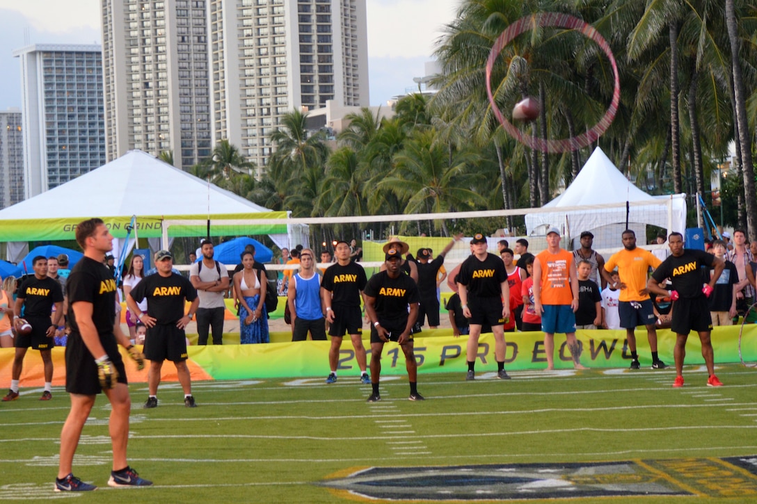 Army 1st Lt. Gary Slother tosses a hula hoop in the air as his teammate throws a football through it during an event for the 2016 Pro Bowl Military Challenge at Queen's Beach in Honolulu, Jan. 29, 2016. Slother is assigned to the 25th Infantry Division's 25th Combat Aviation Brigade. His team placed second in the hula-hoop and football contest. U.S. Army photo by Staff Sgt. Armando R. Limon