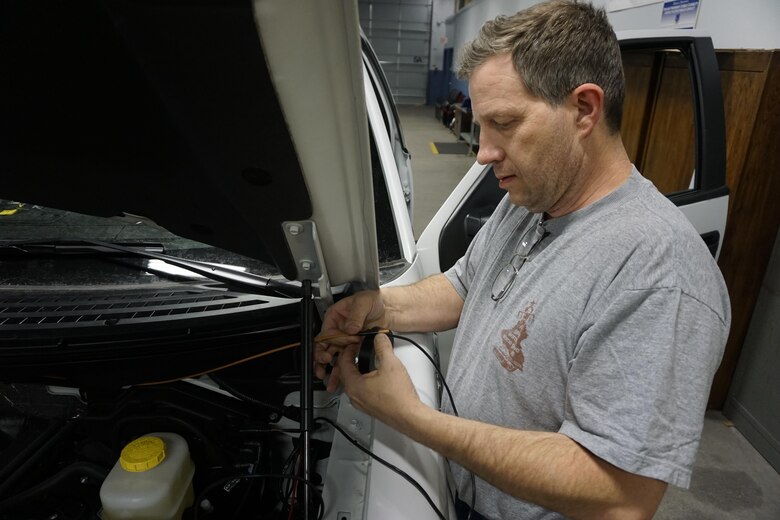 In this file photo dated Jan. 20, 2015, Sean Daugherty, 90th Communications Squadron electronic mechanic, wraps electrical tape over an exposed wire during the installation of new radio equipment in military owned vehicles on F.E. Warren Air Force Base, Wyo. The radio section, in which Daugherty works, maintains communications across the base and throughout its missile complex. (U.S. Air Force photo by Lan Kim)