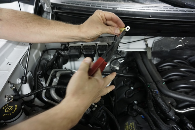 In this file photo dated Jan. 20, 2015, Sean Daugherty, 90th Communications Squadron electronic mechanic, wraps electrical tape over an exposed wire during the installation of new radio equipment in military owned vehicles on F.E. Warren Air Force Base, Wyo. The radio section, in which Daugherty works, maintains communications across the base and throughout its missile complex. (U.S. Air Force photo by Lan Kim)