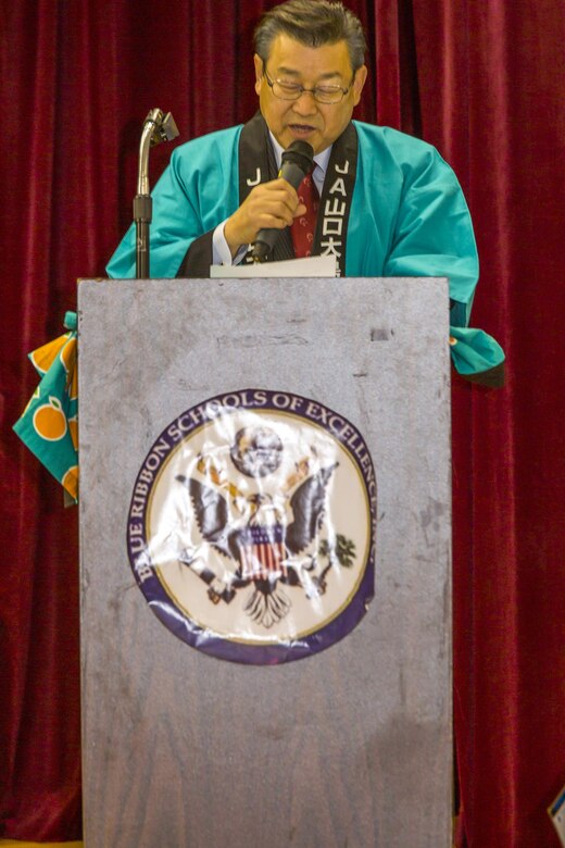 Motoi Yoshimura, leading board director and union president at the Yamaguchi Oshima Agricultural Cooperative Association, gives a speech to Matthew C. Perry Elementary School students during the 6th Annual Mikan Presentation at Marine Corps Air Station Iwakuni, Japan, Feb. 1, 2016. Mikans are orange citrus fruits that resemble tangerines and are a symbol of Japan’s agricultural export business. The event provided students and staff the opportunity to strengthen their bond with Iwakuni residents.