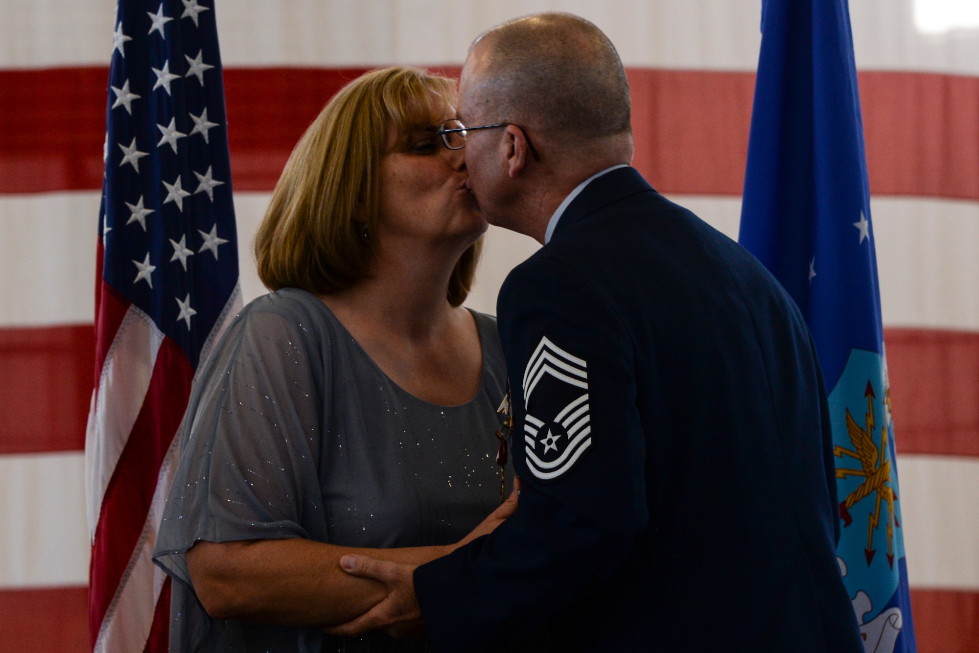 U.S. Air Force Chief Master Sgt. William Medlin, 23d Maintenance Group superintendent, kisses his wife, Dawn, during his retirement ceremony, Jan. 29, 2016, at Moody Air Force Base, Ga. The Medlin’s were recognized for the sacrifices they’ve made throughout the Chief’s career. (U.S. Air Force photo by Airman 1st Class Janiqua P. Robinson/Released)