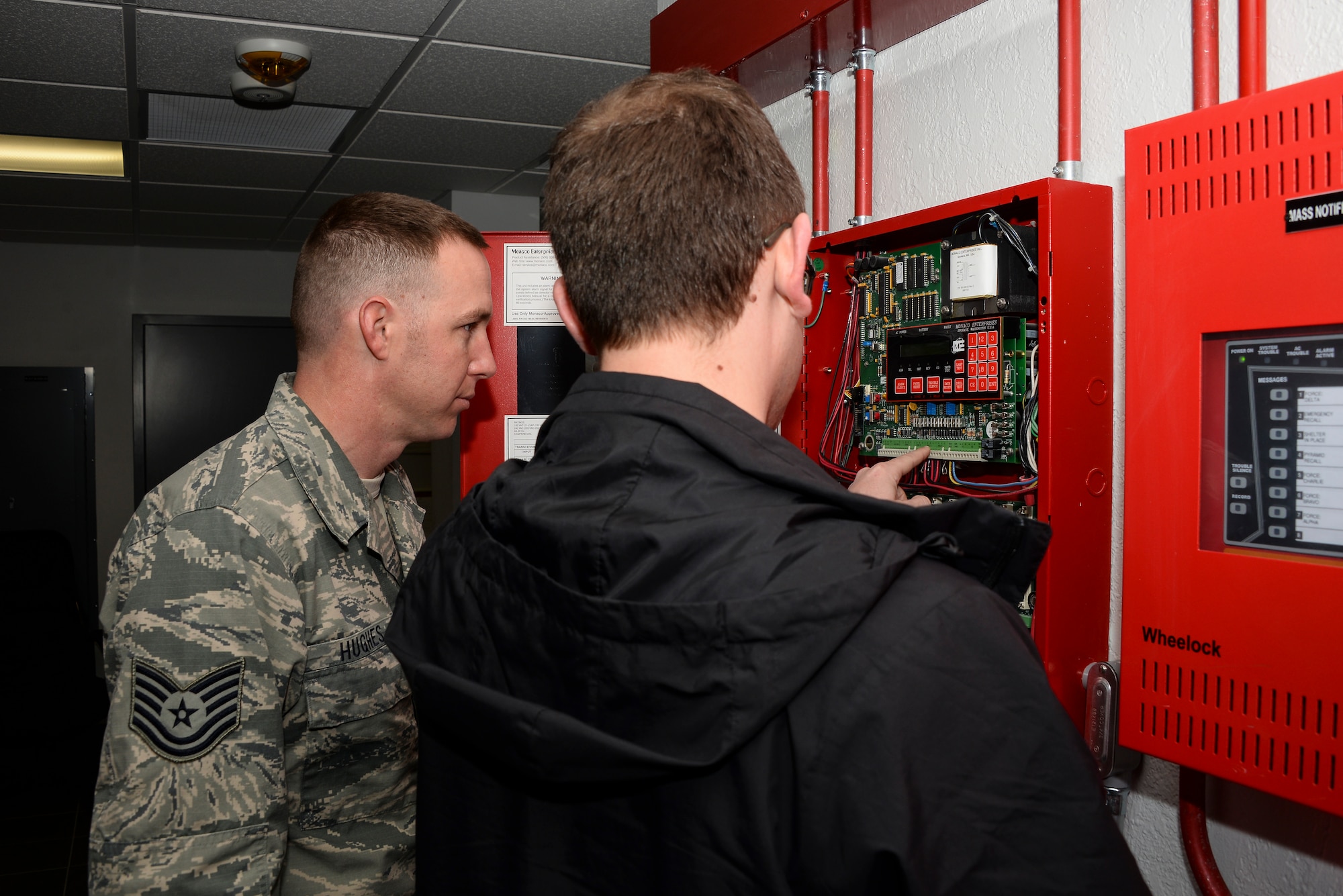 U.S. Air Force Tech. Sgt. Ryan Hughes, 355th Civil Engineer Squadron water fuels system maintenance craftsman, shows Andrew Carmean, Air Force Civil Engineer Center Asset Visibility Team mechanical engineer, a fire alarm control panel during a facility assessment at Davis-Monthan Air Force Base, Ariz., Jan. 28, 2016. The team trained 355th Civil Engineer Squadron Airmen on facility condition assessments. (U.S. Air Force photo by Airman 1st Class Mya M. Crosby/Released)