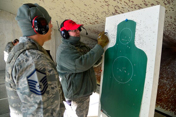 Staff Sgt. Bryan Miller, 436th Security Forces Squadron trainer, draws a sight alignment picture for Master Sgt. David Loera, 436th Logistics Readiness Squadron installation readiness deployment superintendent, during a M9 qualification course Jan. 6, 2016, at the Combat Arms Training and Maintenance facility on Dover Air Force Base, Del. Miller completed more than 60 hours of training to become one of the first certified unit marshals at Dover AFB. (U.S. Air Force photo/Senior Airman William Johnson)