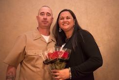 Former Master Chief Petty Officer Jason Roach stands with his wife, Judy, after presenting her roses  during his commissioning ceremony at the Red Bank Club on Joint Base Charleston – Naval Weapons Station, S.C., on Jan. 29, 2016. Roach was commissioned to CWO3 and his next duty station is aboard the USS Eisenhower, a nuclear-powered aircraft carrier. (U.S. Air Force photo/Airman 1st Class Thomas T. Charlton)
