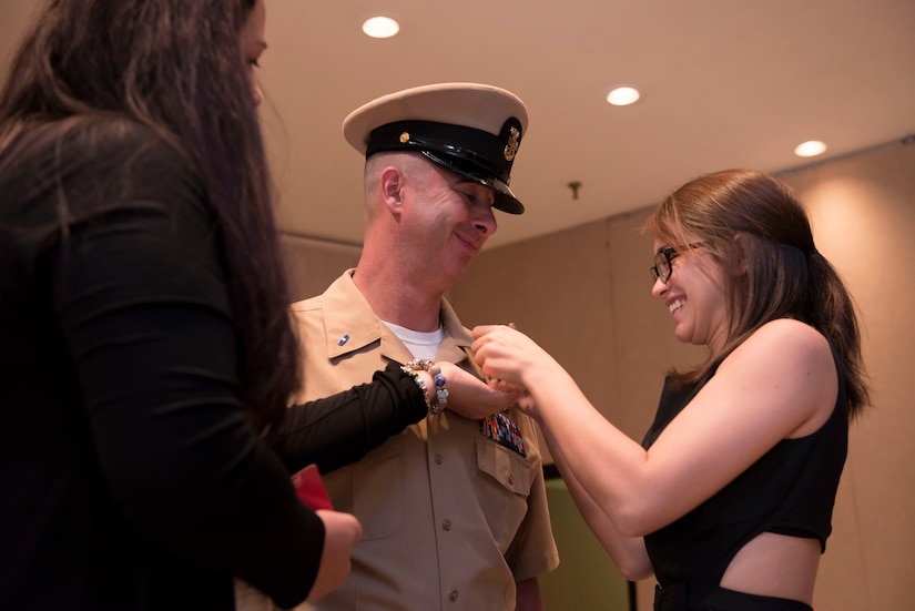 Former MCPO Jason Roach allows his wife, Judy, and his daughter, Samantha Tharas, to pin on his new rank of CWO3 during his commissioning ceremony at the Red Bank Club on Joint Base Charleston, S.C., on Jan. 29, 2016. A CWO is a subject matter expert in a specific occupational field whose knowledge level is beyond what’s expected of senior enlisted members in the same field. (U.S. Air Force photo/Airman 1st Class Thomas T. Charlton)