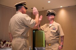 (From left to right) Navy Captain Charles Phillip, Navy Munitions Command Atlanta Unit Charleston commander, swears former MCPO Jason Roach in as a CWO3 during Roach’s commissioning ceremony at the Red Bank Club on Joint Base Charleston – Naval Weapons Station, S.C., on Jan. 29, 2016. (U.S. Air Force photo/Airman 1st Class Thomas T. Charlton)