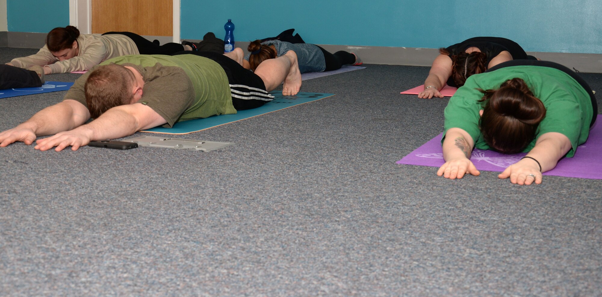 Team Mildenhall members and their families warm up during a yoga class hosted by the 100th Air Refueling Wing Sexual Assault Prevention and Response office Jan. 21, 2016, on RAF Mildenhall, England. The office also host self-defense classes aimed at helping prepare people, physically and mentally for life events. (U.S. Air Force photo by Gina Randall/Released)