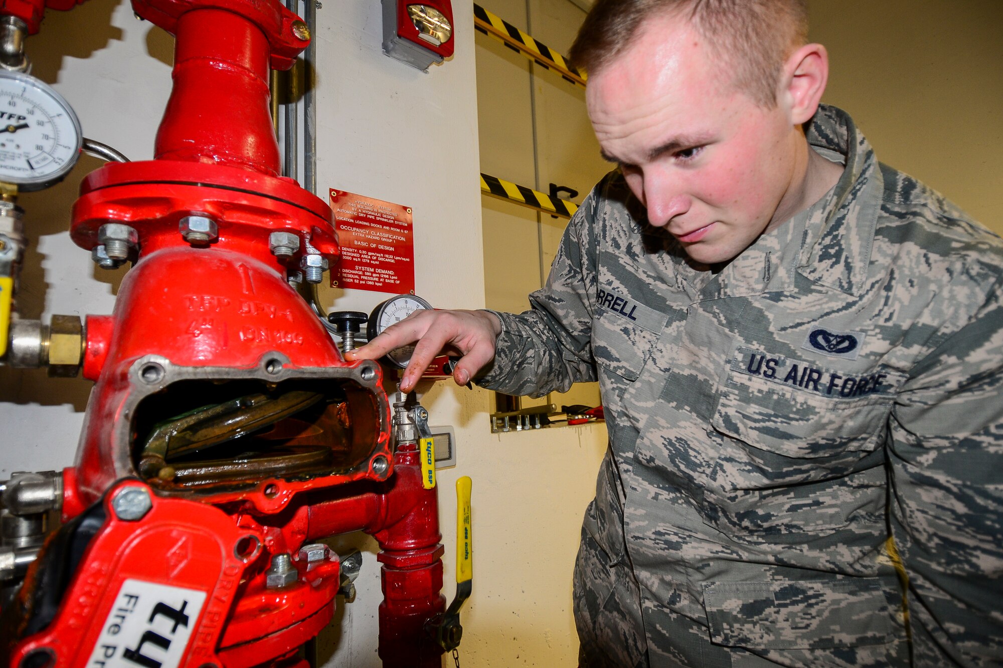 Senior Airman Colton Correll, 31st Civil Engineer Squadron water and fuels systems maintenance journeyman, examines a fire suppression system at Aviano Air Base, Italy, Jan. 26, 2016. Correll and Senior Airman Jacob Neeb, also a 31st CES water and fuels systems maintenance journeyman, are in charge of maintaining and testing more than 65 fire suppression systems here. (U.S Air Force photo by Airman 1st Class Cory W. Bush/Released)
