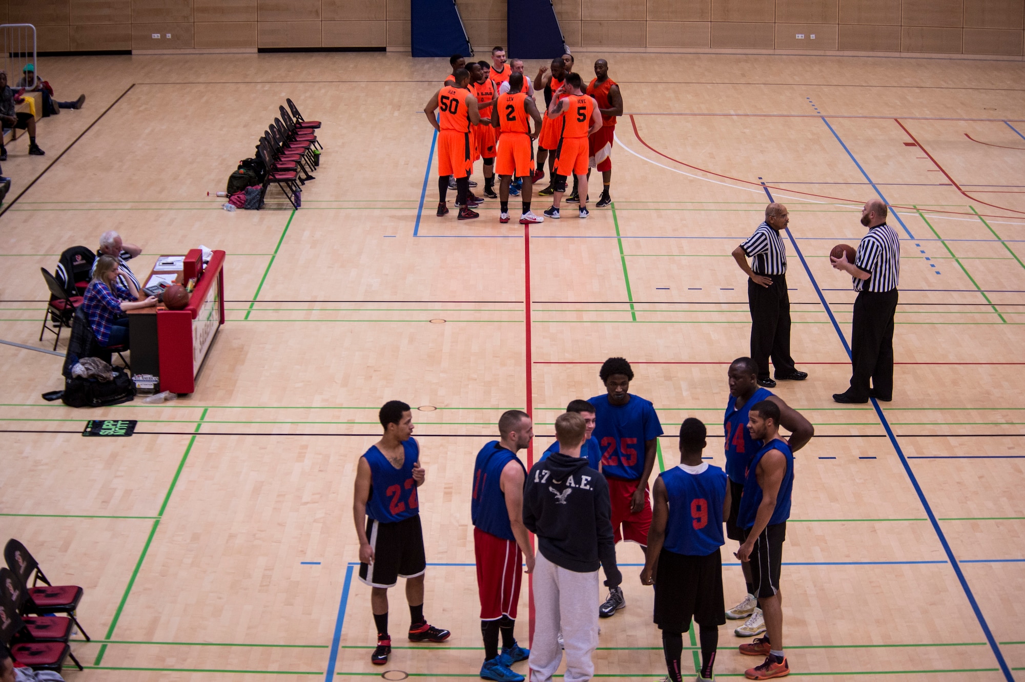 Players and game officials huddle up during a time out during the Intramural Basketball Championship game, inside the George Price Gymnasium Jan. 28, 2016, at Spangdahlem Air Base, Germany. The 52nd LRS won the game with a final score of 54-52. (U.S. Air Force photo by Senior Airman Rusty Frank/Released)