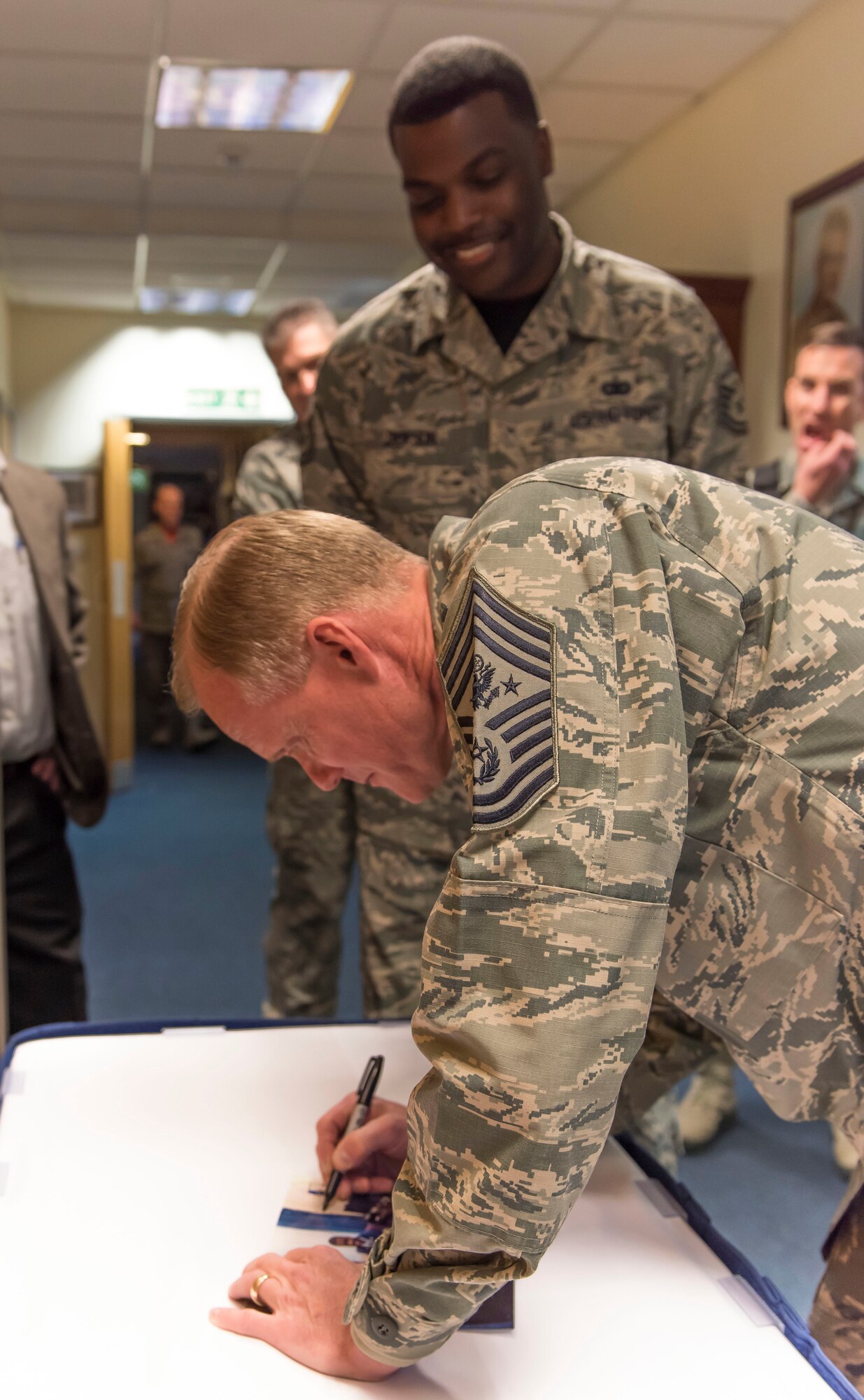 Chief Master Sgt. of the Air Force James Cody signs a photo of Tech. Sgt. Nathan Jackson, Mathies Airman Leadership School instructor, at Royal Air Force Feltwell, England, Jan. 29, 2016. Cody visited the Liberty Wing to discuss a variety of topics and to express his appreciation for the way Liberty Airmen execute the mission and strive for excellence. (U.S. Air Force photo/Senior Airman Trevor T. McBride/Released)