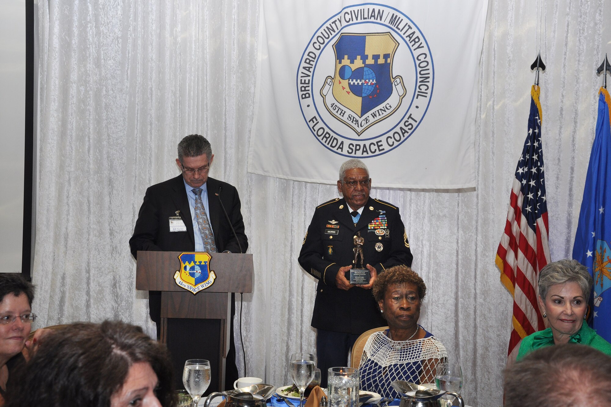 Bill Taylor, CEO of Community Bank of the South and CivMil Member of the Year, and retired Army Sgt. 1st Class Melvin Morris, Medal of Honor recipient, announce the winner of the Melvin Morris Award Jan. 21, 2016, during the CivMil Commander’s Banquet at Patrick Air Force Base, Fla. (U.S. Air Force photo by 1st Lt. Alicia Premo/Released)