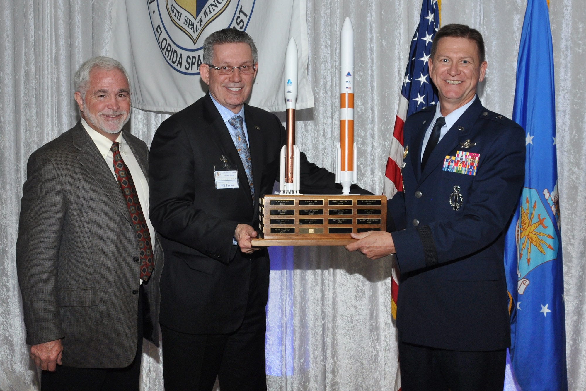 Larry McIntyre, CivMil Chairman of the Board, left, and Brig. Gen. Wayne Monteith, 45th Space Wing commander, right, present Bill Taylor, CEO of Community Bank of the South, with the CivMil Member of the Year Award Jan. 21, 2016, at Patrick Air Force Base, Fla. Taylor was selected as CivMil Member of the Year for conceiving and implementing a community-wide effort to recognize Medal of Honor recipient retired Army Sgt. 1st Class Melvin Morris. (U.S. Air Force photo by 1st Lt. Alicia Premo/Released)