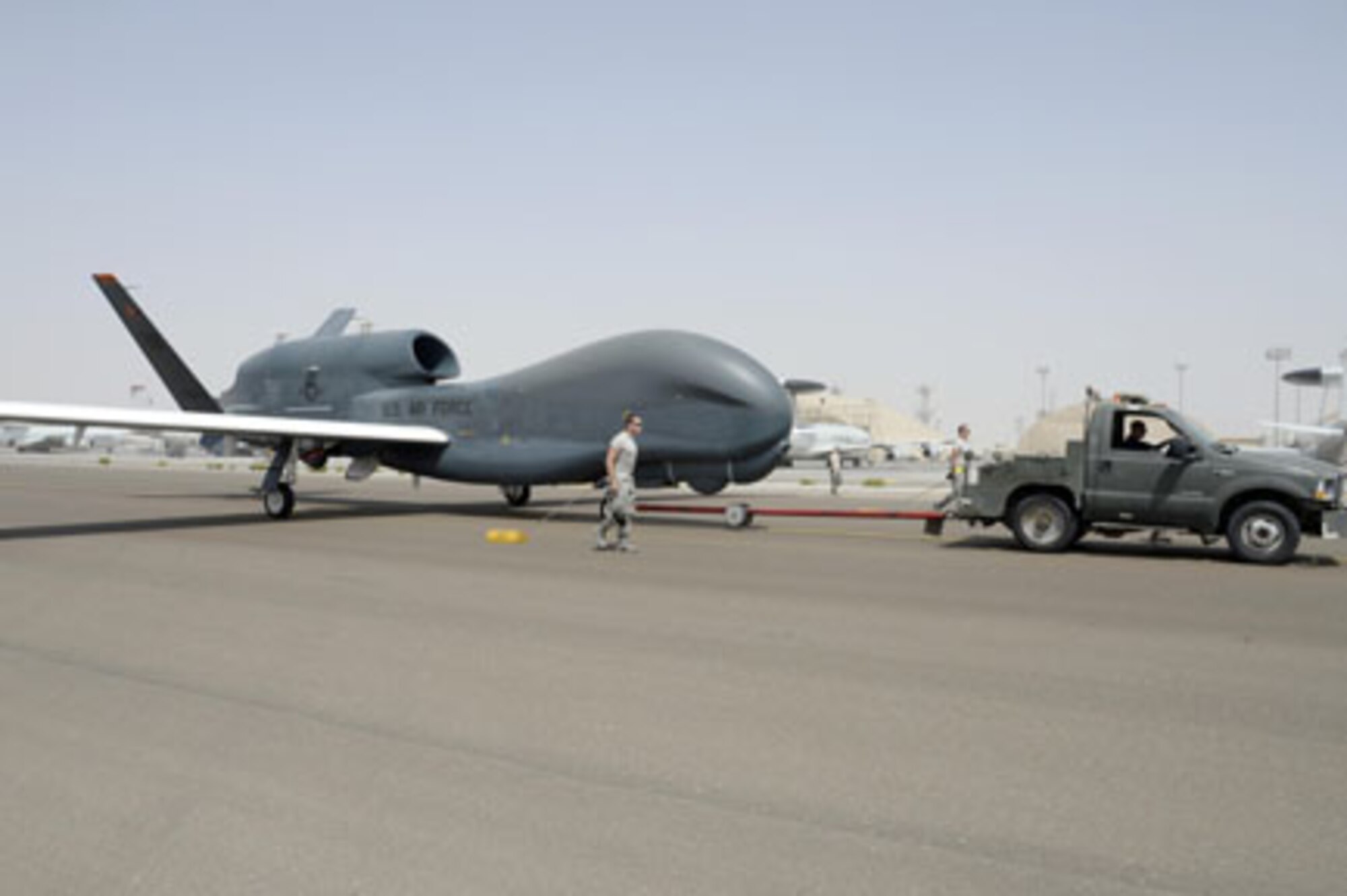 Airmen with the Hawk Aircraft Maintenance Unit walk in a RQ-4 Global Hawk after it landed from a 30.5 hour flight at an undisclosed location in Southwest Asia in March 2015. This is a block 20 aircraft that carries the Battlefield Airborne Communication Node payload, which ensures connectivity for warfighters. The BACN system, managed out of Hanscom Air Force Base, Mass., recently achieved 100,000 combat flight hours.  (U.S. Air Force photo/Tech. Sgt. Marie Brown) 
