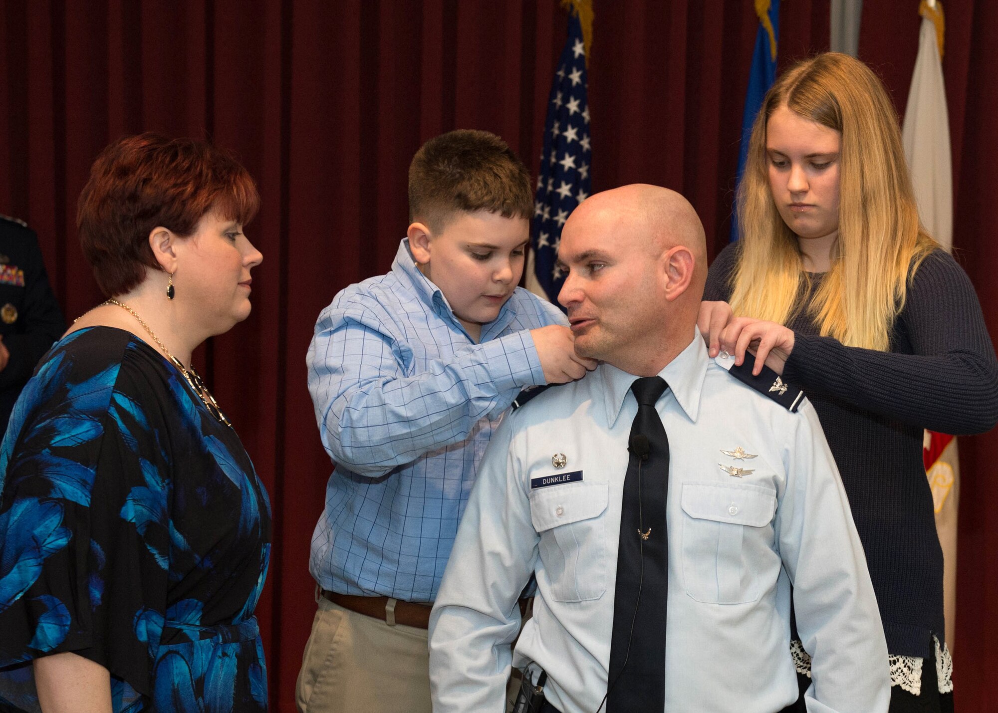 Col. David R. Dunklee, commander of the 66th Air Base Group, stands as his children, Nate and Emily, pin on his new rank during a promotion ceremony Jan. 29 at the Minuteman Commons, while his wife, Kathy, watches. Following the promotion, Lt. Gen. John F. Thompson, Air Force Life Cycle Management Center commander, also officially appointed Dunklee to command of the 66th Air Base Group. During his remarks, Dunklee highlighted the importance of family, including his own and the ABG and Hanscom family. (U.S. Air Force photo by Jerry Saslav)
