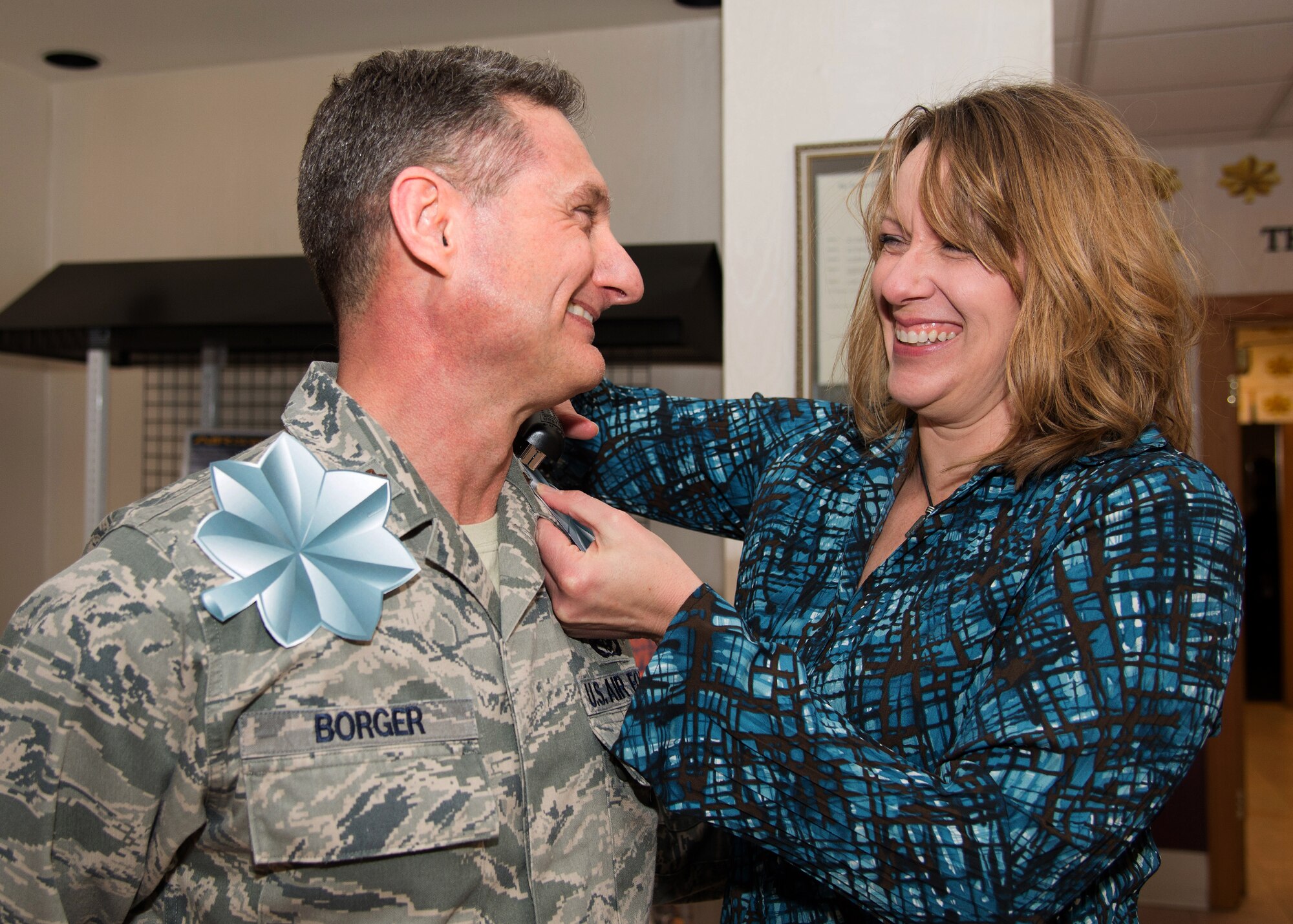 Chaplain (Maj.) Robert Borger is all smiles as his wife, Jennifer, attaches his selected rank during a promotion selection celebration at the Minuteman Commons Jan. 28. Earlier in the week, Air Force officials announced the names of Airmen selected for promotion to the rank of major and lieutenant colonel. (U.S. Air Force photo by Mark Herlihy)