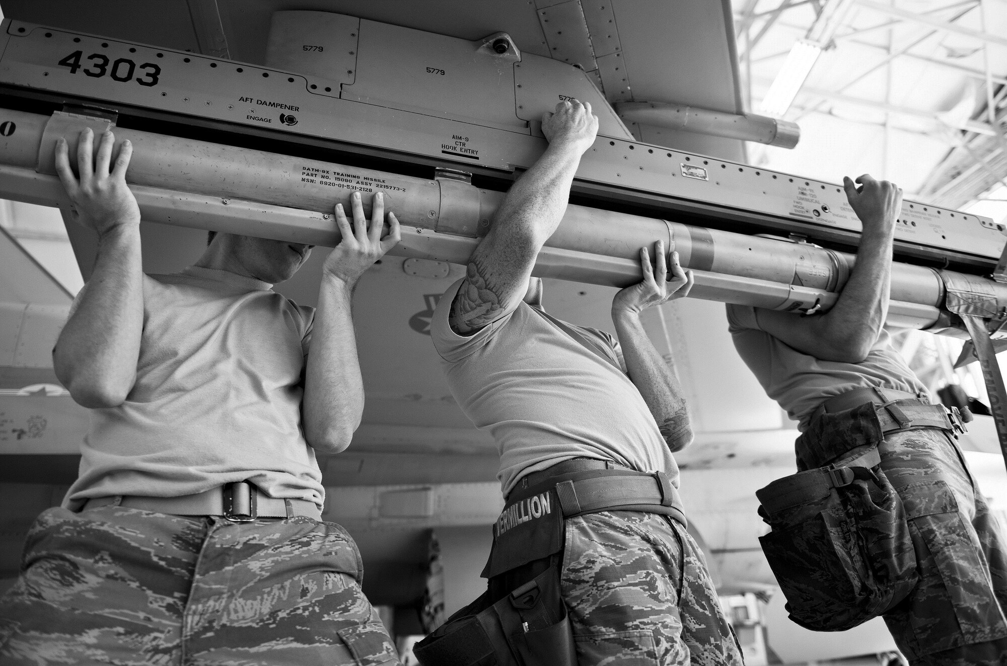 A 96th Aircraft Maintenance Squadron Blue team lifts an AIM-9 to an F-16 Fighting Falcon during the Loadcrew of the Year competition at Eglin Air Force Base, Fla., Jan. 29.  Two F-16 loadcrews battled two F-15 Eagle loadcrews for the best time and fewest mistakes while loading three missiles to their respective aircraft.  The winners will be revealed at the annual 96th Maintenance Group banquet in March.  (U.S. Air Force photo/Samuel King Jr.)