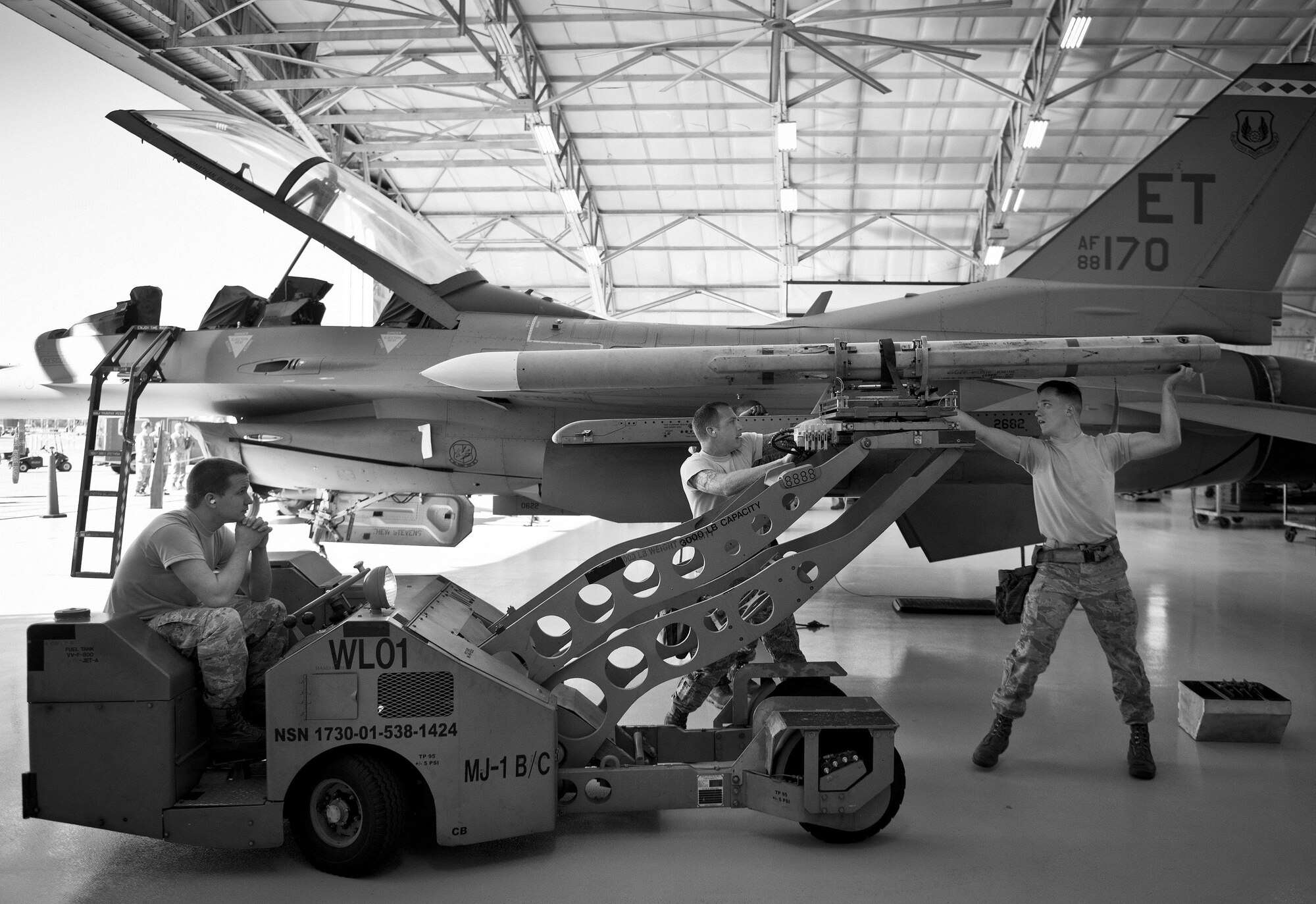 A 96th Aircraft Maintenance Squadron Blue team places an AIM-120 to an F-16 Fighting Falcon during the Loadcrew of the Year competition at Eglin Air Force Base, Fla., Jan. 29.  Two F-16 loadcrews battled two F-15 Eagle loadcrews for the best time and fewest mistakes while loading three missiles to their respective aircraft.  The winners will be revealed at the annual 96th Maintenance Group banquet in March.  (U.S. Air Force photo/Samuel King Jr.)