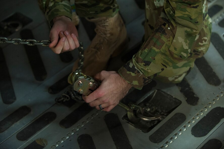 An Airman with the 33rd Helicopter Maintenance Unit secures an HH-60 Pave Hawk to the deck of a C-17 Globemaster III, Jan. 26, 2016, at Kadena Air Base. The HH-60 is capable of performing civil search and rescue, emergency aeromedical evacuation, disaster relief and international aid. (U.S. Air Force photo by Airman 1st Class Nick Emerick)