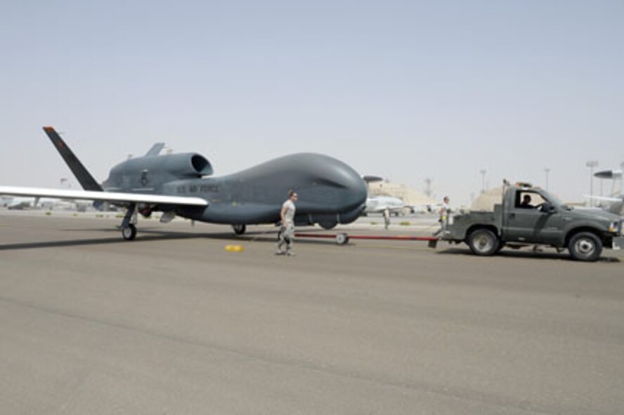 Airmen with the Hawk Aircraft Maintenance Unit walk in a RQ-4 Global Hawk after it landed from a 30.5 hour flight at an undisclosed location in Southwest Asia in March 2015. This is a block 20 aircraft that carries the Battlefield Airborne Communication Node payload, which ensures connectivity for warfighters. The BACN system, managed out of Hanscom Air Force Base, Mass., recently achieved 100,000 combat flight hours.  (U.S. Air Force photo/Tech. Sgt. Marie Brown) 
