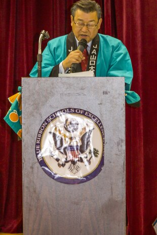 Motoi Yoshimura, leading board director and union president at the Yamaguchi Oshima Agricultural Cooperative Association, gives a speech to Matthew C. Perry Elementary School students during the 6th Annual Mikan Presentation at Marine Corps Air Station Iwakuni, Japan, Feb. 1, 2016. Mikans are orange citrus fruits that resemble tangerines and are a symbol of Japan’s agricultural export business. The event provided students and staff the opportunity to strengthen their bond with Iwakuni residents.