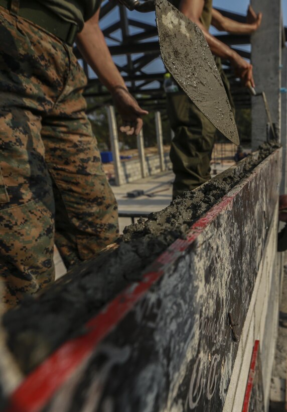 U.S. Marine Corps Lance Cpl. Jacqueline Hein, combat engineer, with Marine Wing Support Squadron 171 smoothens concrete during the building of a multi-purpose room for the Banchamkho school during exercise Cobra Gold 2016 in Rayong, Kingdom of Thailand, Jan. 30, 2016. Cobra Gold 2016, in its 35th iteration, includes a specific focus on Humanitarian Civic Action, community engagement, and medical activities conducted during the exercise to support the needs and humanitarian interests of civilian populations around the region.