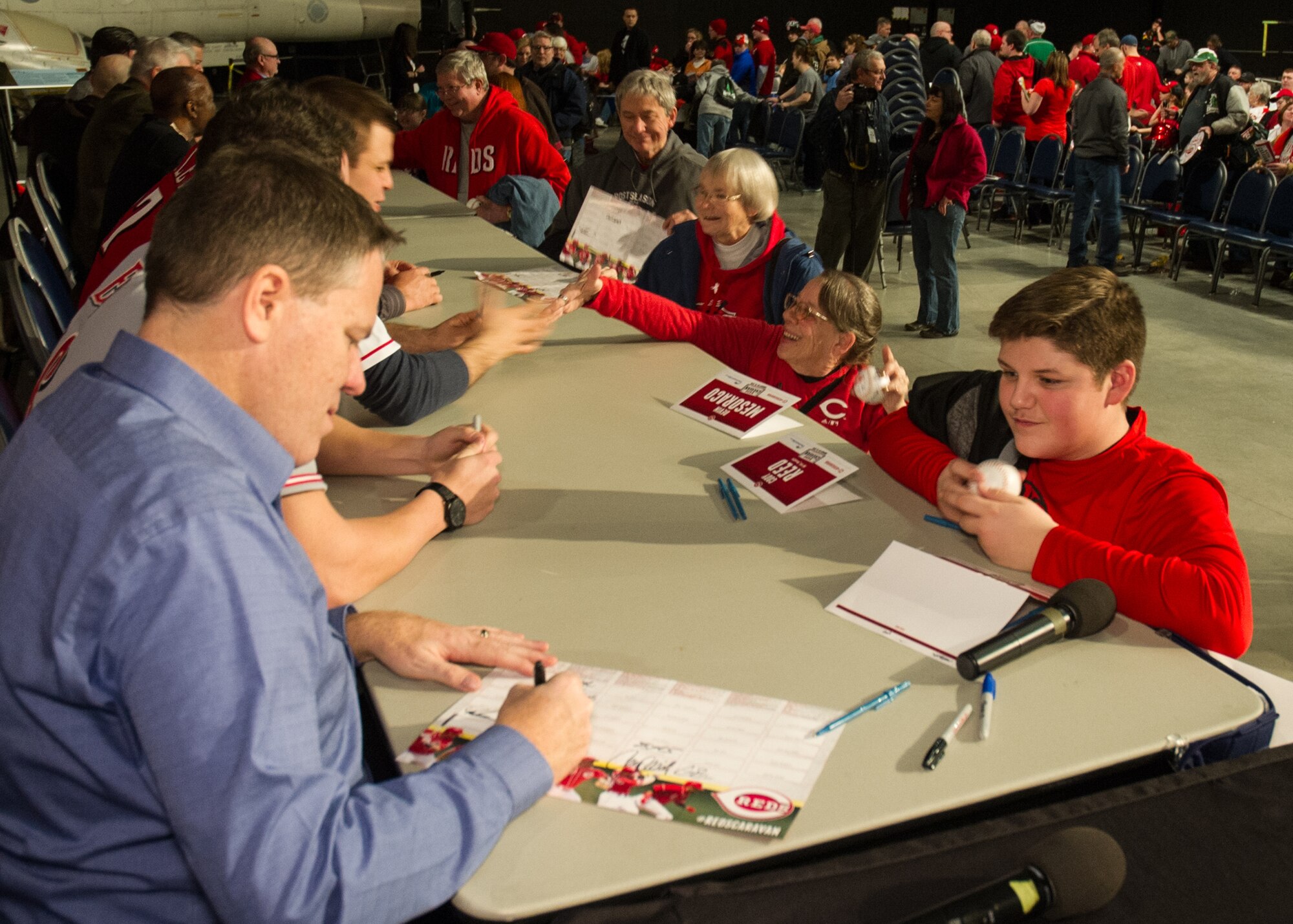 National Museum of the U.S. Air Force visitors had the opportunity to meet members of the Cincinnati Reds organization on January 30th, 2016. Here a fan receives and autograph from broadcaster Jim Day. Catcher Devin Mesoraco; president of baseball operations Walt Jocketty; minor league pitcher Cody Reed; former catcher Corky Miller; owner Bob Castellini; chief operating officer Phil Castellini; Baseball Hall of Famer Joe Morgan; broadcaster Thom Brennaman and mascot Mr. Redlegs were also at the museum stop. (U.S. Air Force photo)