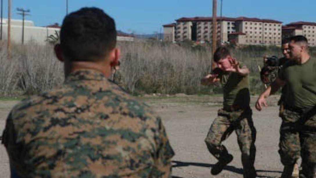 While under the blinding effect of oleoresin capsicum (OC) spray, Marines are led through an obstacle course by an instructor of a non-lethal weapons course, at Marine Corps Base Camp Pendleton, California, Jan. 26, 2016. During the course, Marines learned various techniques such as lower and upper body strikes and take-down control techniques. They also learned riot control and detainee handling. The Marines are with Company B, 1st Combat Engineer Battalion, 1st Marine Division, I Marine Expeditionary Force. 