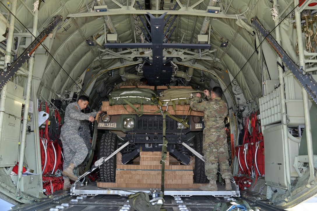 Service members inspect two parachute-rigged Humvees in an Air Force C-130 Hercules aircraft on Aviano Air Base, Italy, Jan. 21, 2016. Army photo by Paolo Bovo