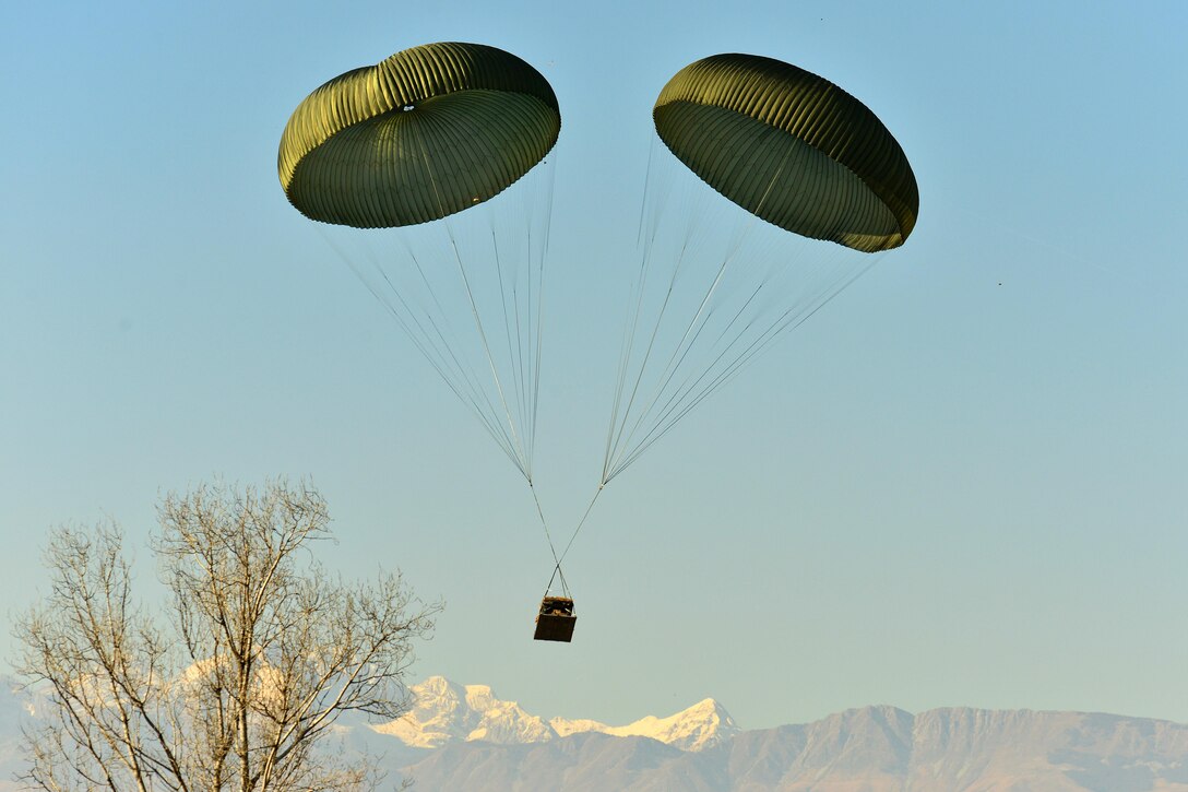 A Humvee descends onto Frida IV drop zone after being dropped from an Air Force C-130 Hercules aircraft in Pordenone, Italy, Jan. 21, 2016. Army photo by Paolo Bovo