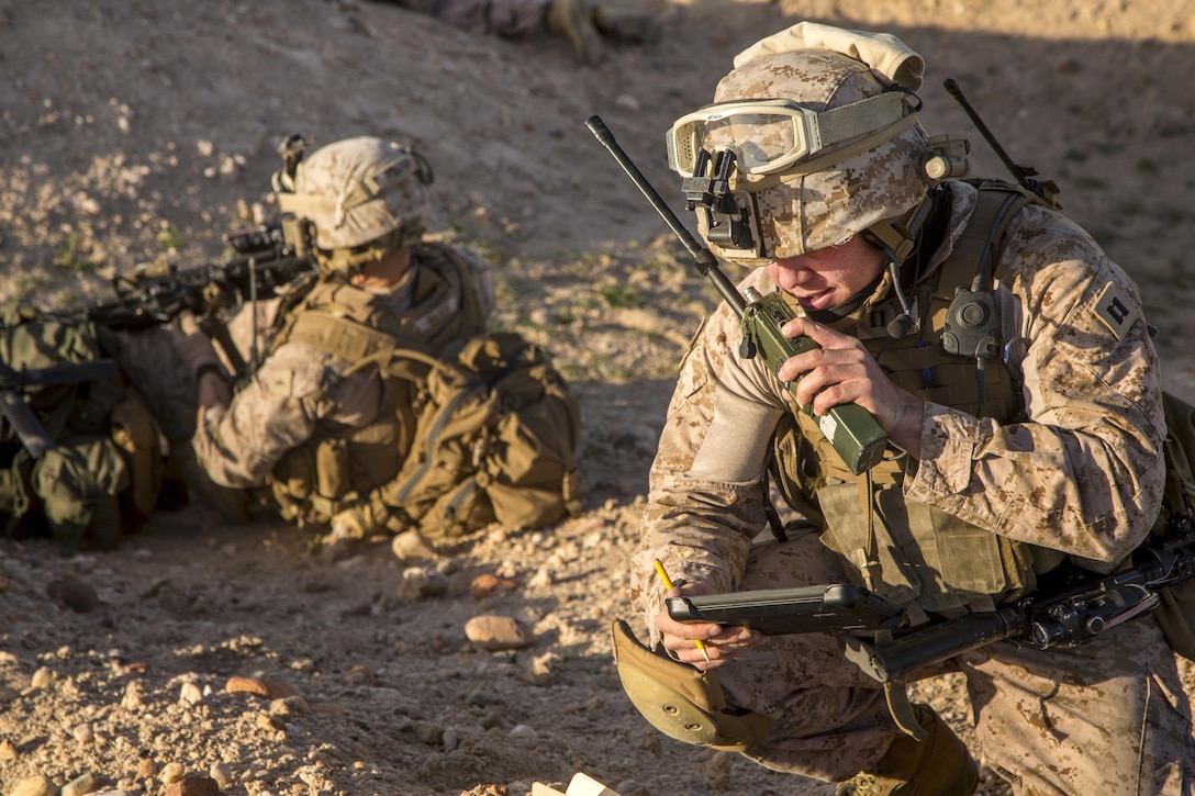 Marine Corps Capt. Alexander Smith, foreground, communicates coordinates with air support during a tactical exercise to recover aircraft and personnel at an undisclosed location in Southwest Asia, Jan. 25, 2016. Smith is a forward air controller assigned to Charlie Company, 1st Battalion, 7th Marine Regiment, Special Purpose Marine Air-Ground Task Force Crisis Response Central Command. Marine Corps photo by Cpl. Akeel Austin