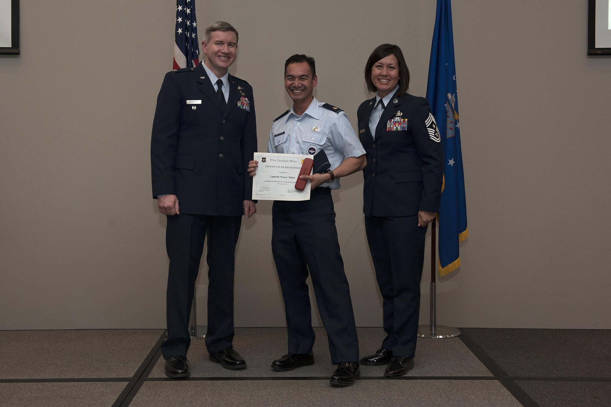 U.S. Air Force Col. Terry J. Hamrick, 17th Training Wing Vice Commander, and Chief Master Sgt. JoAnne S. Bass, 17th TRW Command Chief, present the Company Grade Officer of the Quarter award to Maj. Carlos H. Montances, 315th Training Squadron instructor, on behalf of Capt. Travis White, 315th TRS, during the wing quarterly awards ceremony at the Event Center on Goodfellow Air Force Base, Texas, Jan. 29, 2016. (U.S. Air Force photo by Airman 1st Class Caelynn Ferguson/Released)