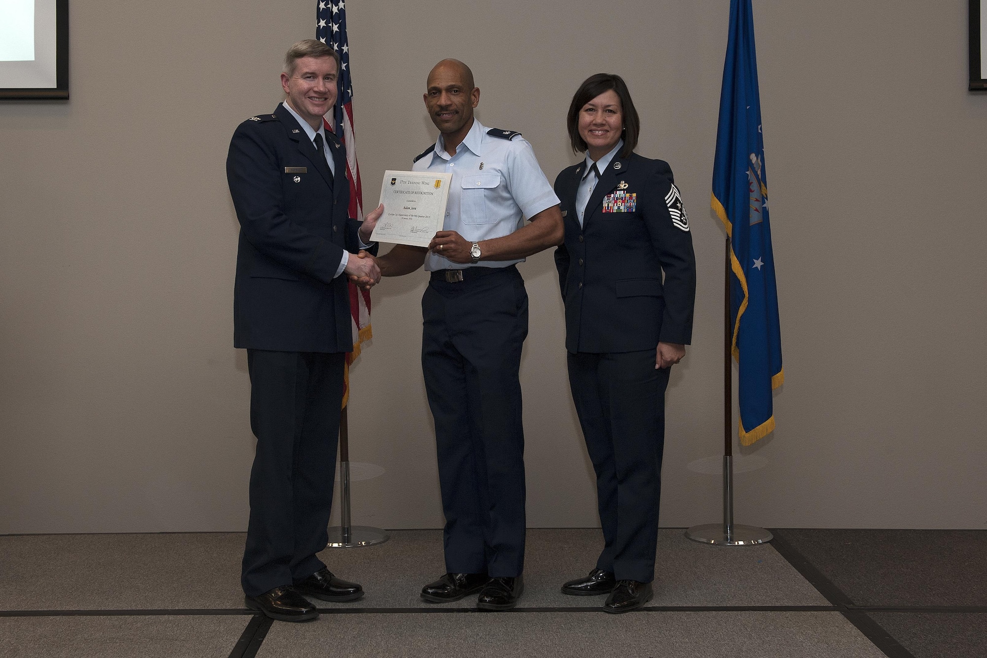 U.S. Air Force Col. Terry J. Hamrick, 17th Training Wing Vice Commander, and Chief Master Sgt. JoAnne S. Bass, 17th TRW Command Chief, present the Civilian Categor I Supervisory of the Quarter award to Lt. Col. Bernard Vanpelt, 17th Medical Support Squadron Commander, on behalf of Adam Jara, 17th MDSS, during the wing quarterly awards ceremony at the Event Center on Goodfellow Air Force Base, Texas, Jan. 29, 2016. (U.S. Air Force photo by Airman 1st Class Caelynn Ferguson/Released)