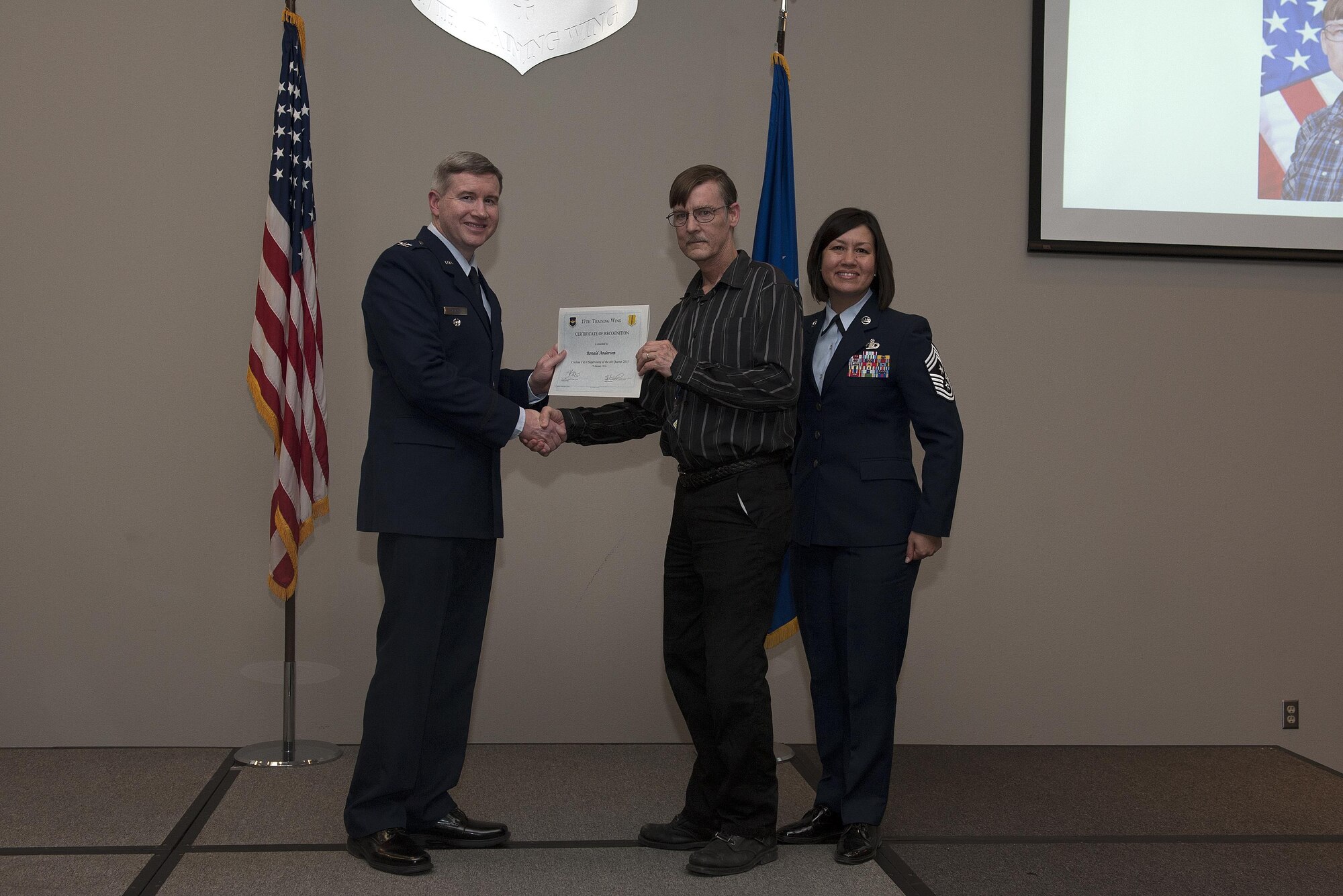 U.S. Air Force Col. Terry J. Hamrick, 17th Training Wing Vice Commander, and Chief Master Sgt. JoAnne S. Bass, 17th TRW Command Chief, present the Civilian Category II Supervisory of the Quarter award to Ronald Anderson, 17th Training Support Squadron, during the wing quarterly awards ceremony at the Event Center on Goodfellow Air Force Base, Texas, Jan. 29, 2016. (U.S. Air Force photo by Airman 1st Class Caelynn Ferguson/Released)