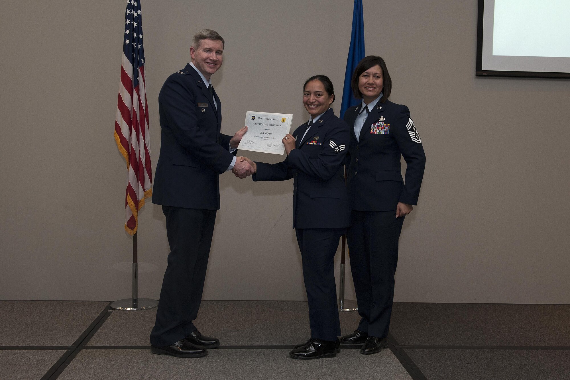 U.S. Air Force Col. Terry J. Hamrick, 17th Training Wing Vice Commander, and Chief Master Sgt. JoAnne S. Bass, 17th TRW Command Chief, present the Honor Guard of the Quarter award to Senior Airman Jill Yopp, 17th Communications Squadron, during the wing quarterly awards ceremony at the Event Center on Goodfellow Air Force Base, Texas, Jan. 29, 2016. (U.S. Air Force photo by Airman 1st Class Caelynn Ferguson/Released)