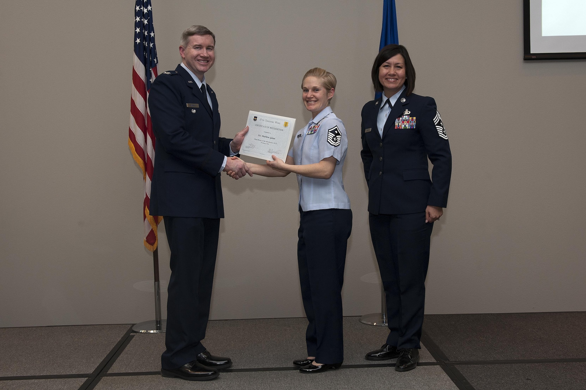 U.S. Air Force Col. Terry J. Hamrick, 17th Training Wing Vice Commander, and Chief Master Sgt. JoAnne S. Bass, 17th TRW Command Chief, present the Dorm Room of the Quarter award to Master Sgt. Brenda J. Dodson, 17th Force Support Squadron first sergeant, on behalf of Airman 1st Class Mathew Glenn, 17th Civil Engineer Squadron, during the wing quarterly awards ceremony at the Event Center on Goodfellow Air Force Base, Texas, Jan. 29, 2016. (U.S. Air Force photo by Airman 1st Class Caelynn Ferguson/Released)